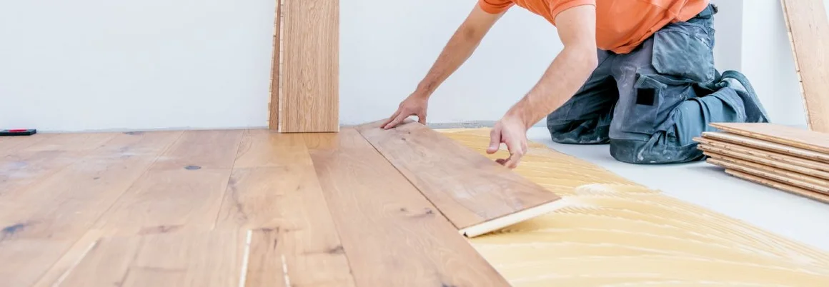 Handwerker verlegt Boden in einem modernen Neubauhaus.